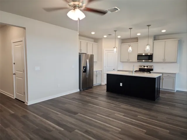 a kitchen with a sink stainless steel appliances a counter space and cabinets