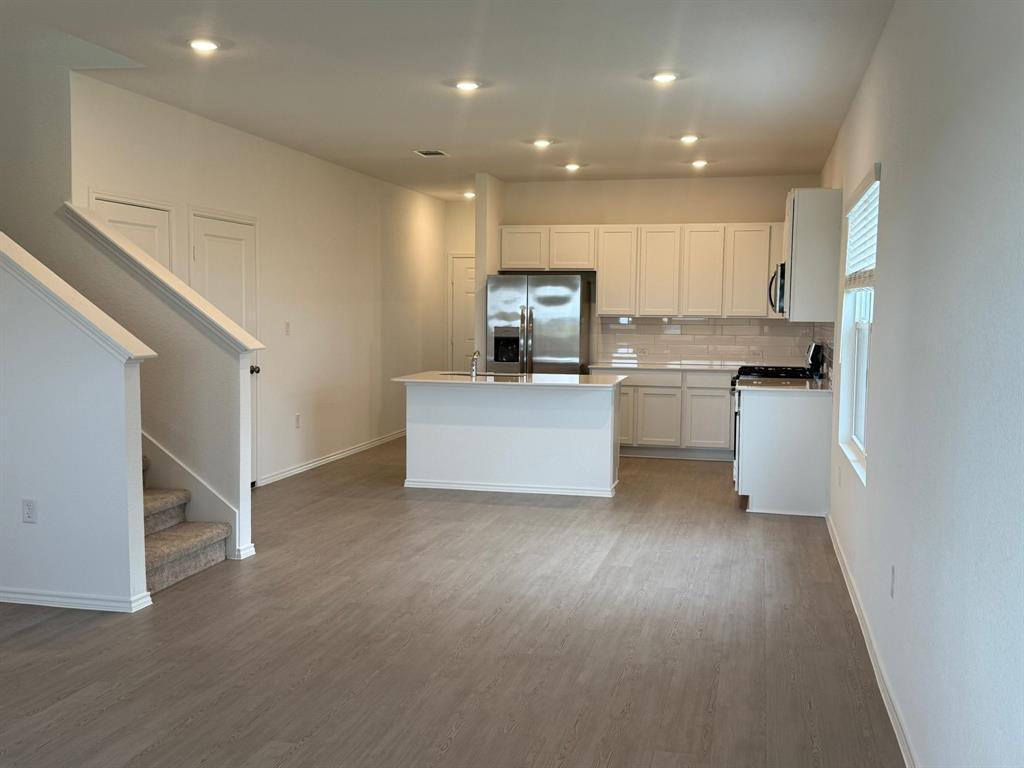 106 Brabham Loop Hutto, TX 78634 - Photo 15 of 40 Open-concept living space featuring wood-finish flooring, recessed lighting, and a modern kitchen