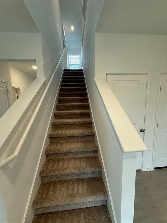 106 Brabham Loop Hutto, TX 78634 - Photo 17 of 40 Carpeted staircase with white balustrade and handrail