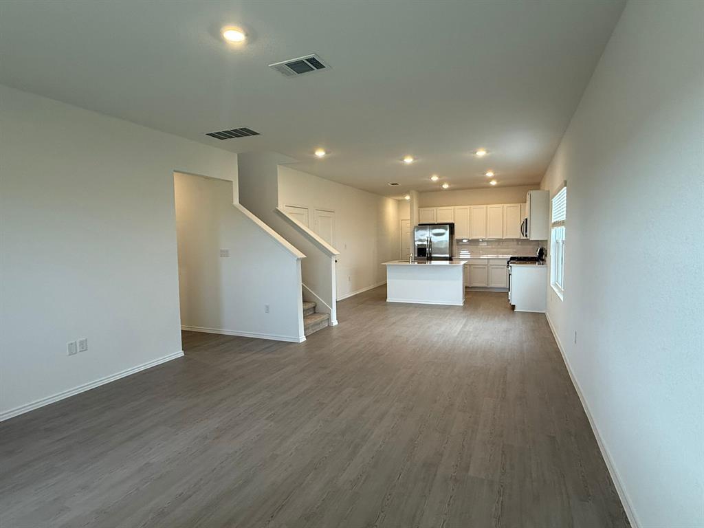106 Brabham Loop Hutto, TX 78634 - Photo 18 of 40 Open-concept living space featuring wood-finish flooring, recessed lighting, and a contemporary kitchen