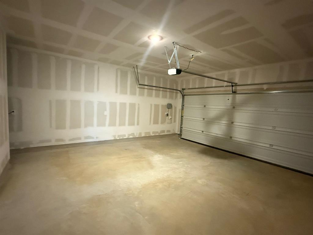 106 Brabham Loop Hutto, TX 78634 - Photo 20 of 40 Spacious two-car garage featuring a concrete floor, automatic overhead door, and ceiling-mounted garage door opener