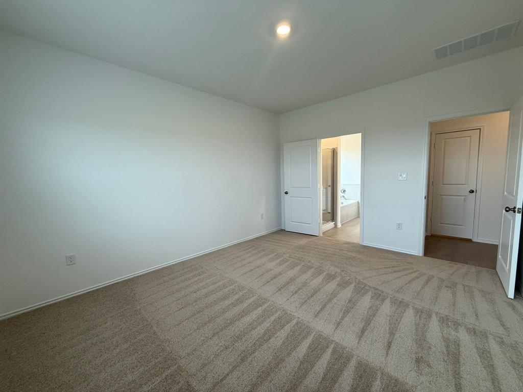 106 Brabham Loop Hutto, TX 78634 - Photo 29 of 40 Spacious room featuring neutral carpeting, white walls, and bright overhead lighting