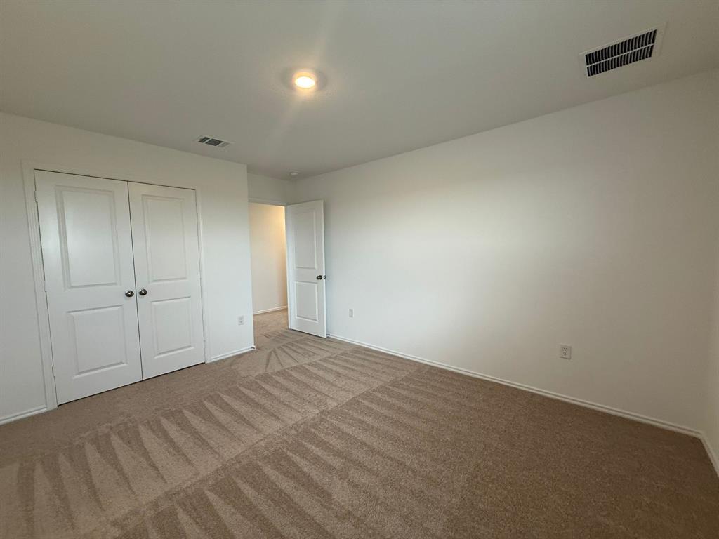 106 Brabham Loop Hutto, TX 78634 - Photo 34 of 40 Carpeted room featuring a double-door closet, white walls, and a recessed ceiling light