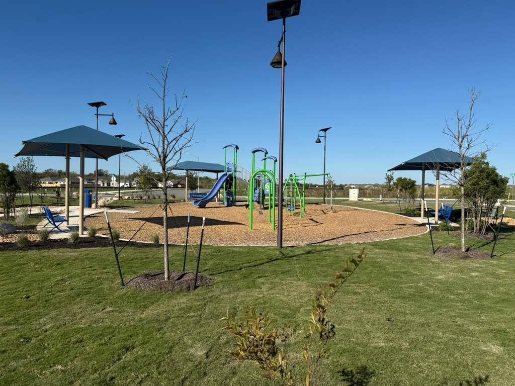 106 Brabham Loop Hutto, TX 78634 - Photo 40 of 40 Community playground featuring multiple play structures, a slide, swings, and climbing elements