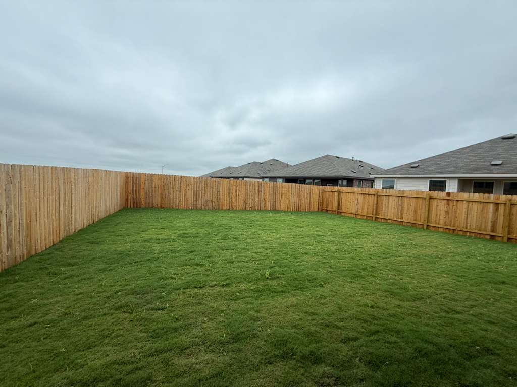 106 Brabham Loop Hutto, TX 78634 - Photo 6 of 40 Expansive green lawn enclosed by new wooden fencing