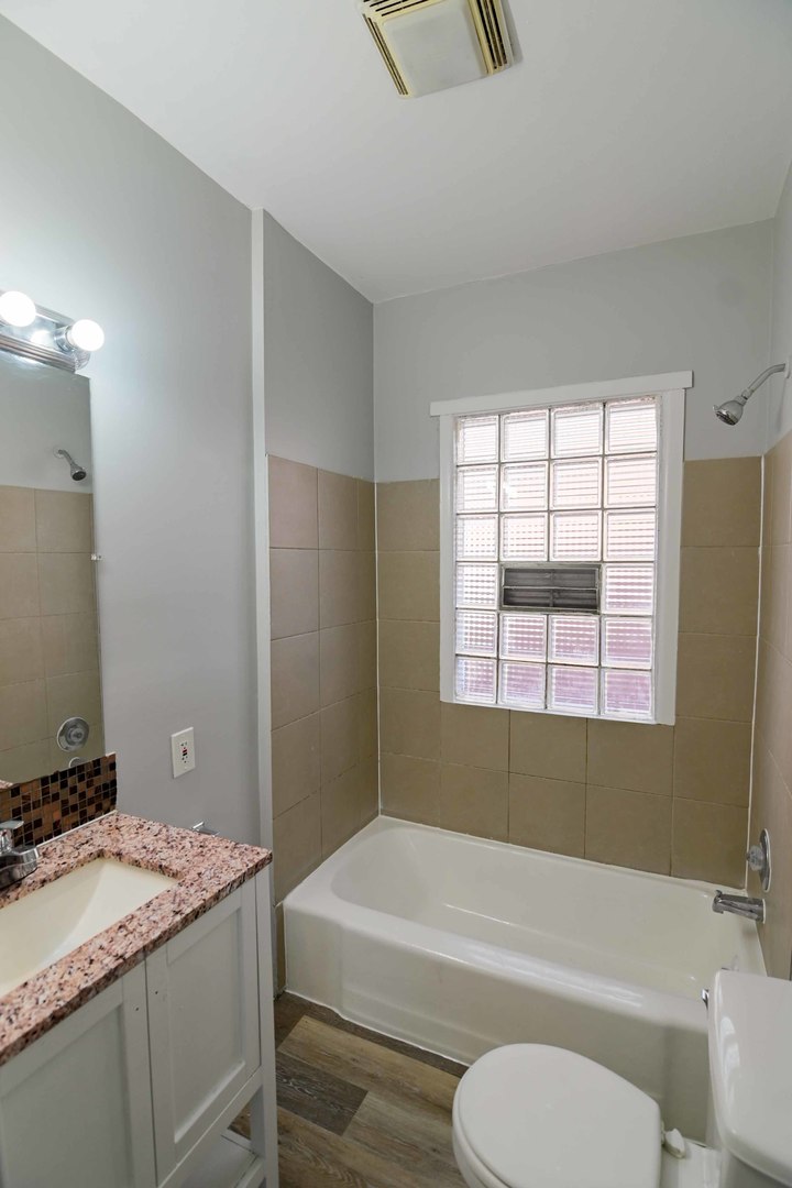 817 11th Street North Chicago, IL 60064 - Photo 22 of 45 a bathroom with a granite countertop toilet sink and mirror