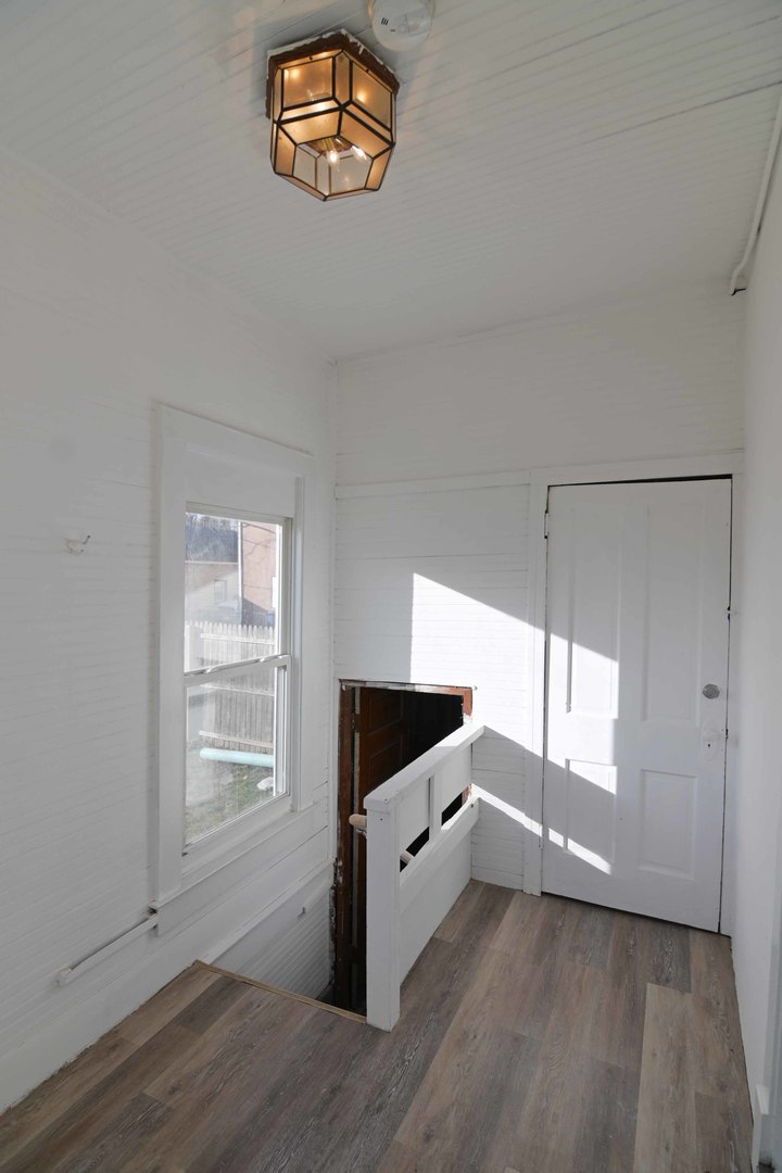 817 11th Street North Chicago, IL 60064 - Photo 29 of 45 a view of an empty room with a window and wooden floor