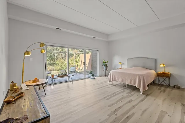 a spacious bedroom with a bed and wooden floor