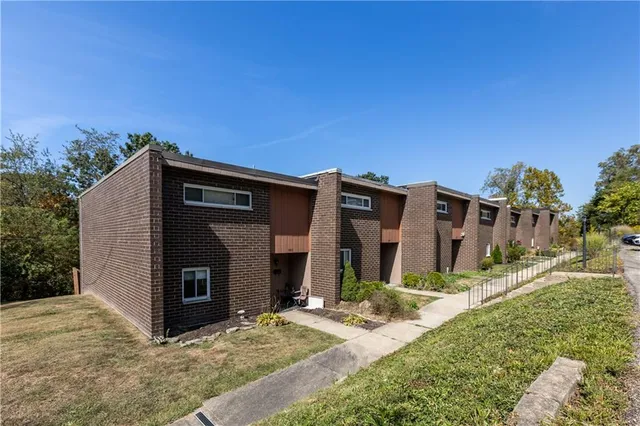 a view of house with yard and car parked