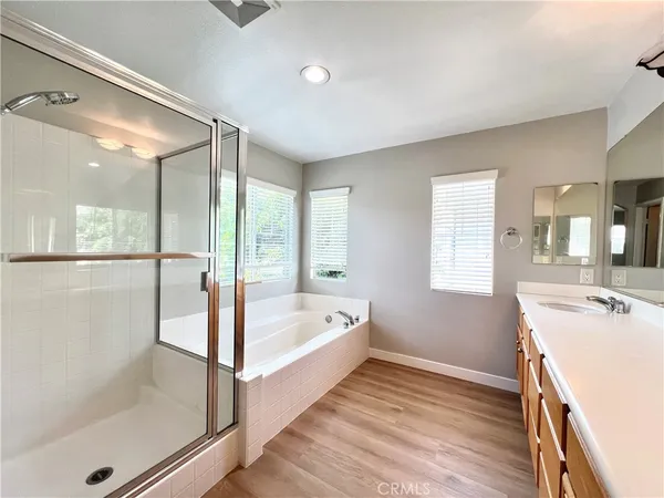 a spacious bathroom with a tub sink and mirror