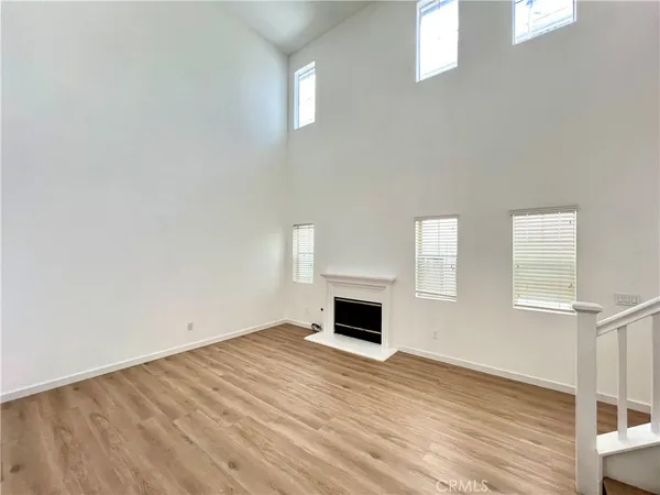 a view of empty room with wooden floor and fireplace