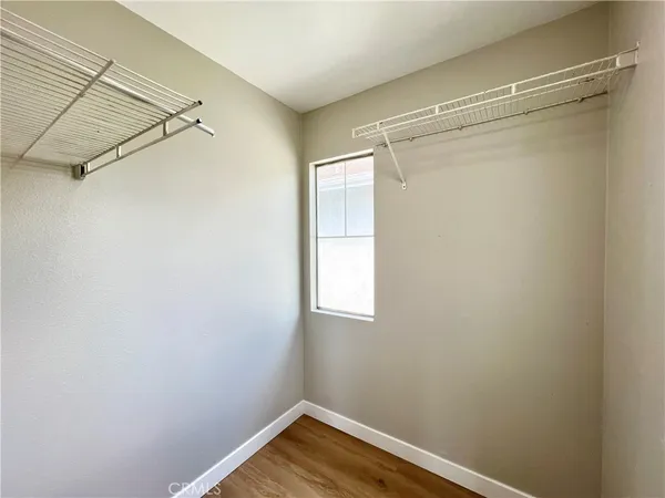 a view of a small space with wooden floor closet and windows