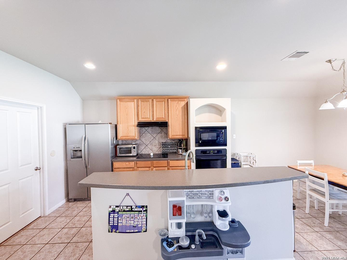 13715 Jubilee Way Helotes, TX 78023 - Photo 13 of 34 a kitchen with a refrigerator and a stove top oven