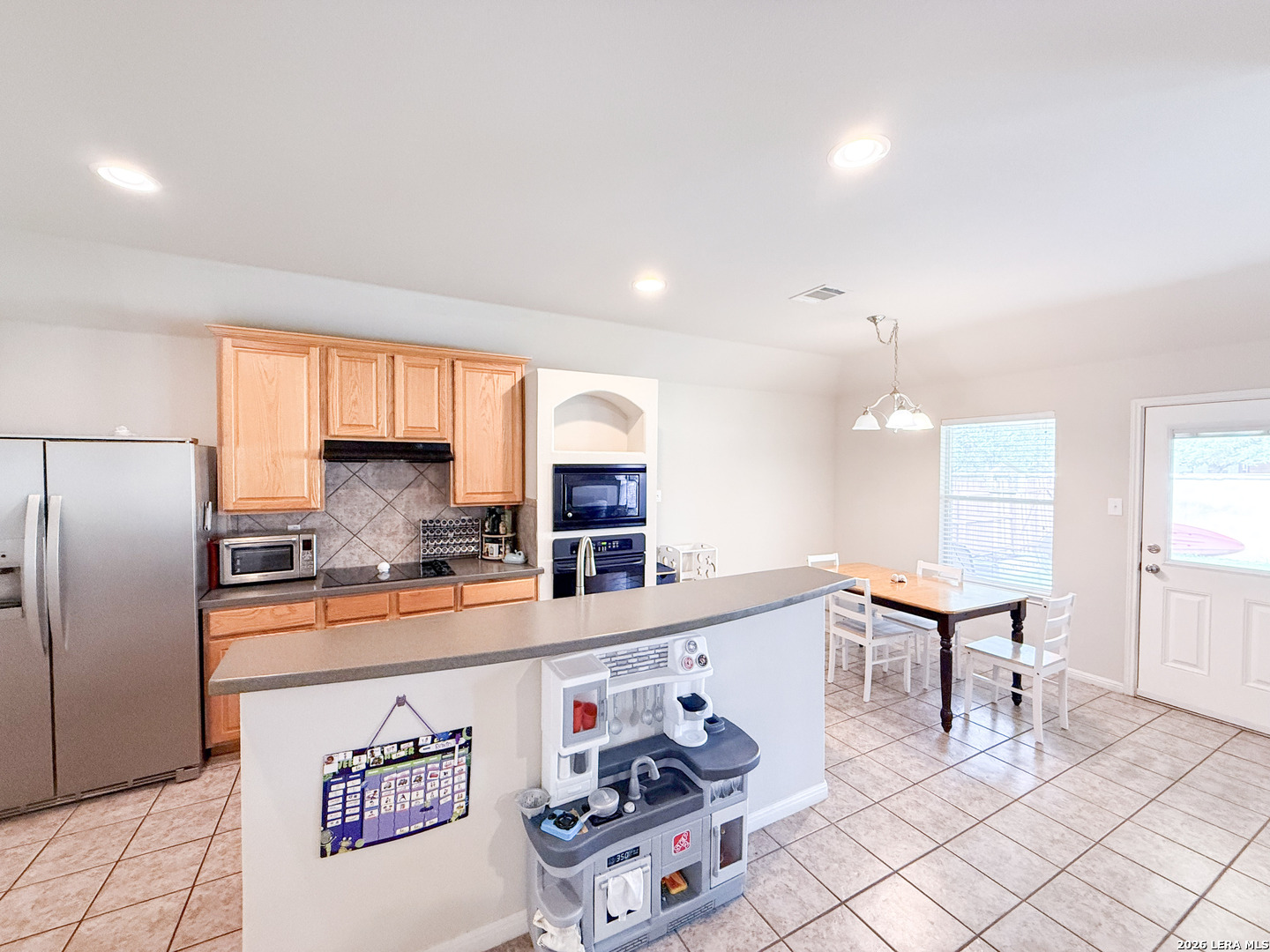 13715 Jubilee Way Helotes, TX 78023 - Photo 14 of 34 a kitchen with stainless steel appliances granite countertop a refrigerator sink and cabinets
