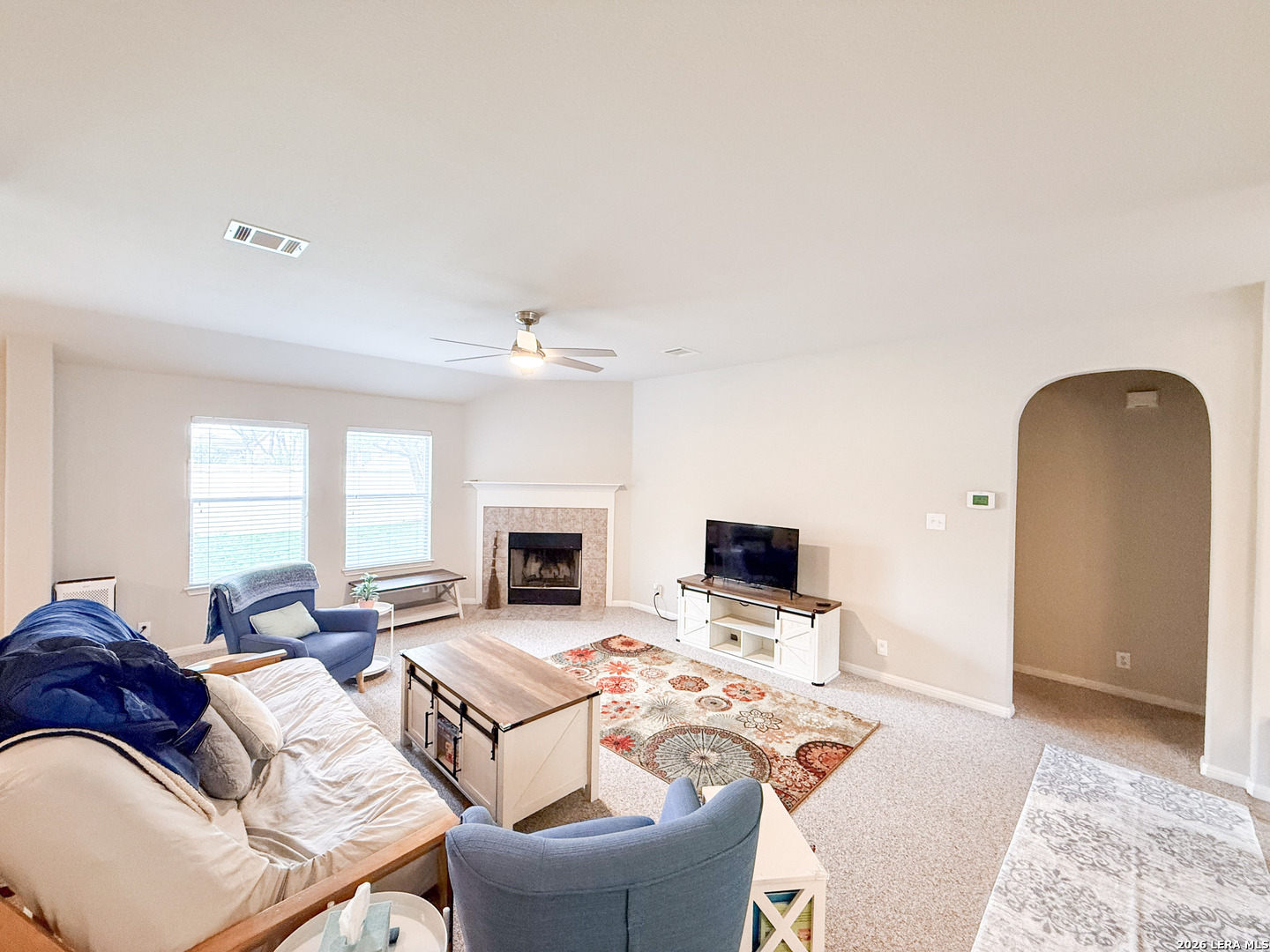 13715 Jubilee Way Helotes, TX 78023 - Photo 15 of 34 a living room with furniture a fireplace and a flat screen tv