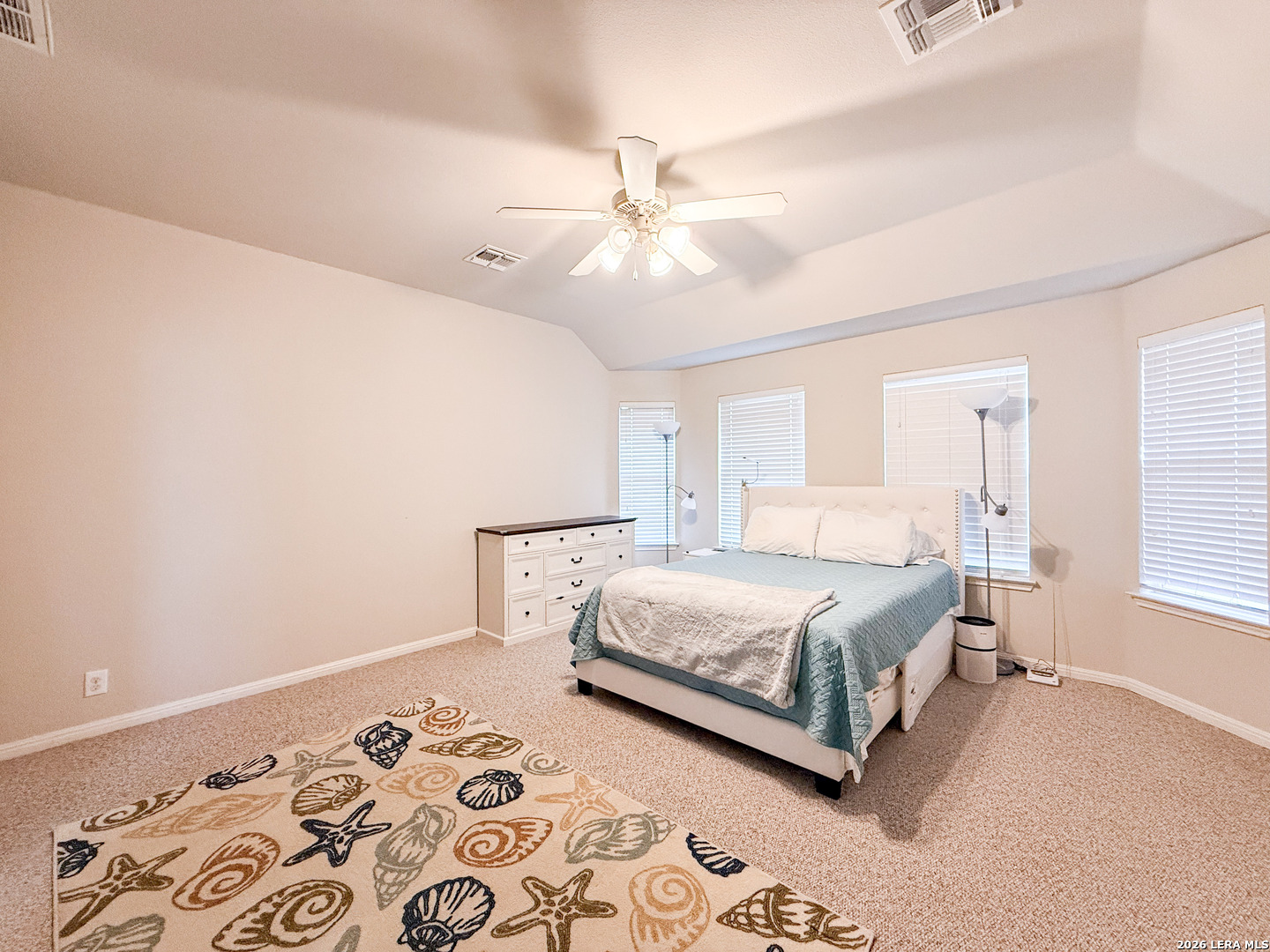 13715 Jubilee Way Helotes, TX 78023 - Photo 18 of 34 a bedroom with a large bed and a chandelier