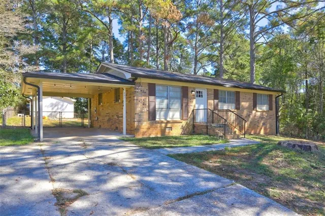 a view of a house with backyard and a tree