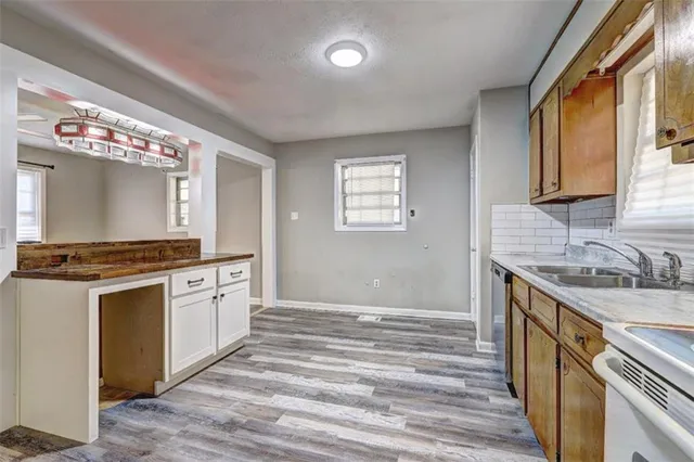 a kitchen with granite countertop a sink cabinets and wooden floor