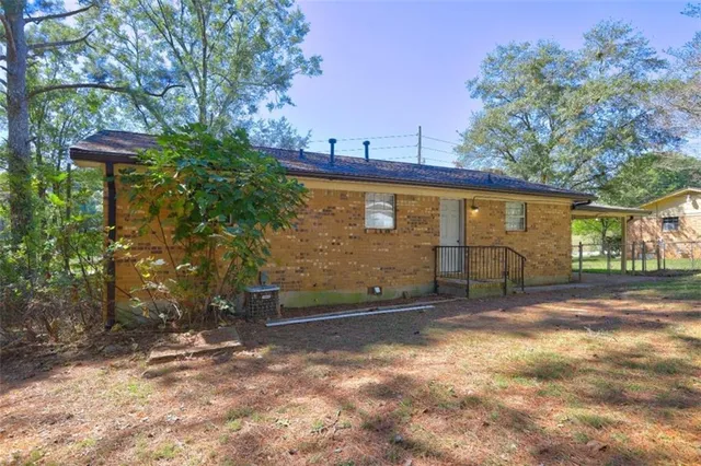 a view of a house with backyard and trees