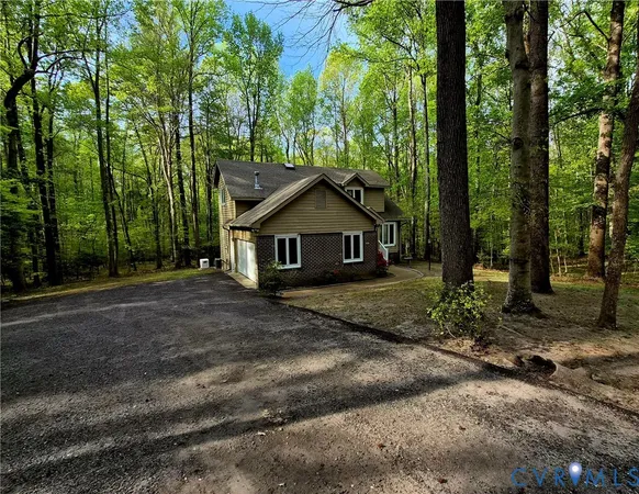 a front view of a house with a yard and large tree