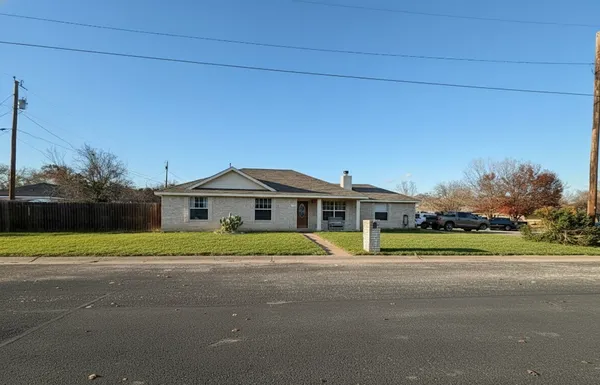 a front view of a house with a yard and trees