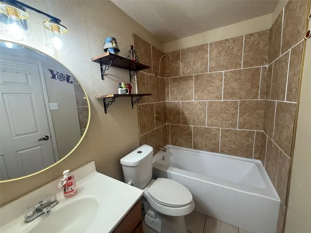 a white toilet sitting next to a bath tub