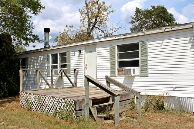 a front view of a house with a tree