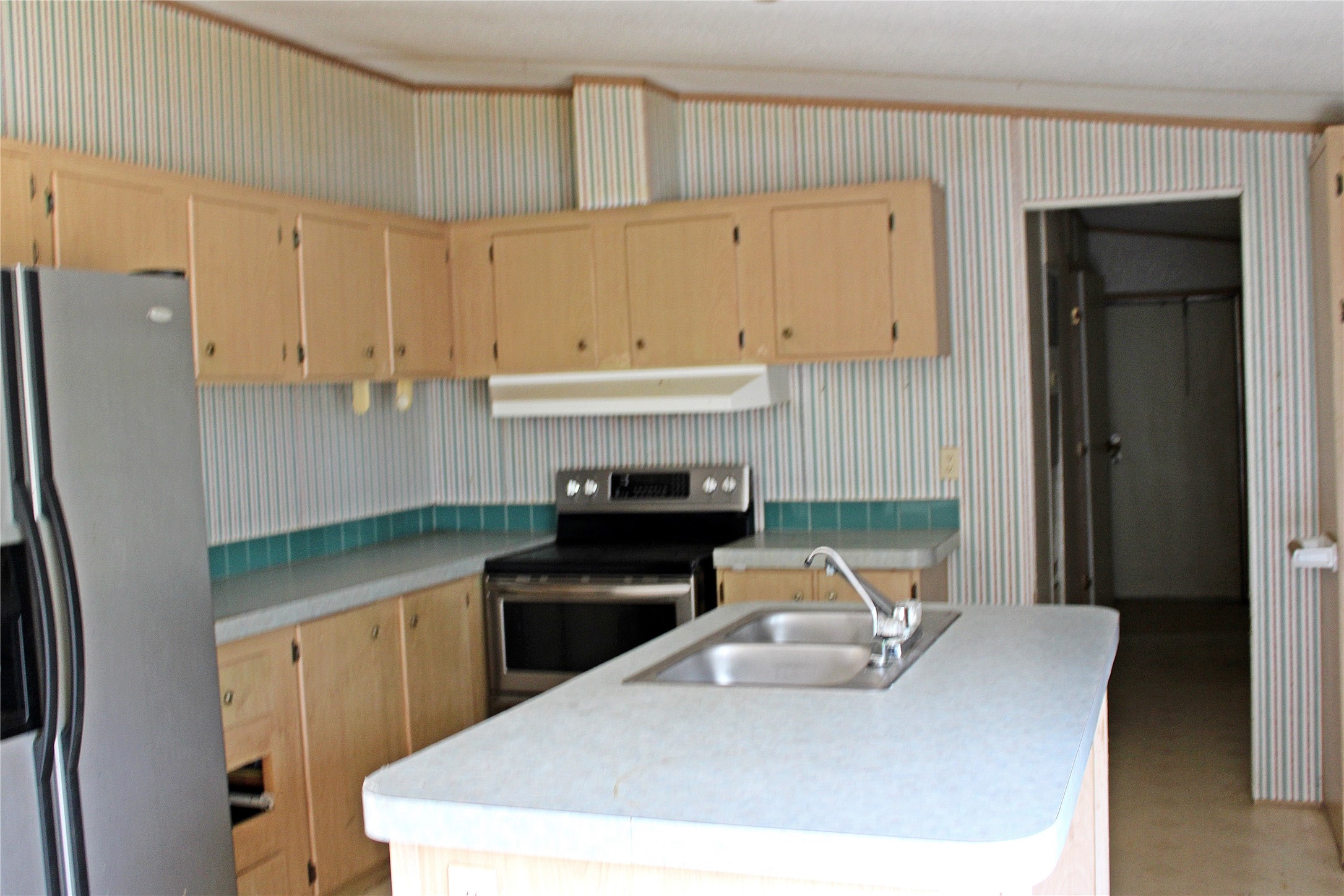 601 Travis Street Alleyton, TX 78935 - Photo 2 of 17 a kitchen with a sink a refrigerator and cabinets