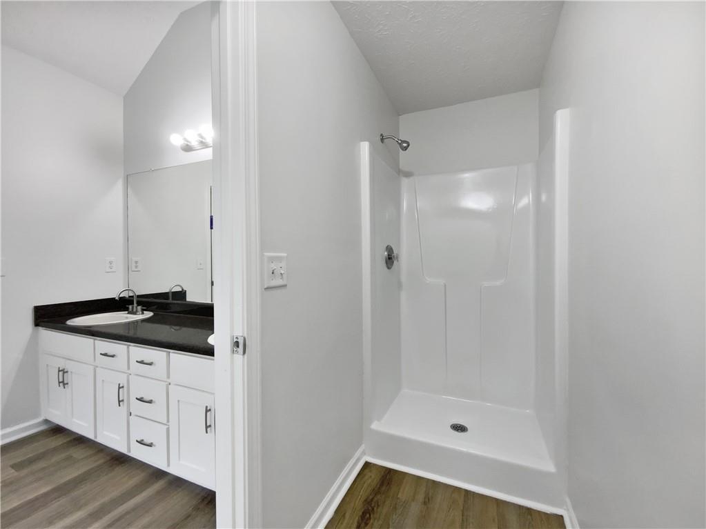 107 Jasons Ridge Griffin, GA 30223 - Photo 18 of 24 a bathroom with a granite countertop sink a mirror a bathtub and shower