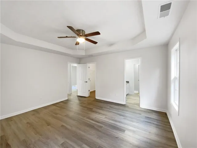 a view of an empty room with wooden floor