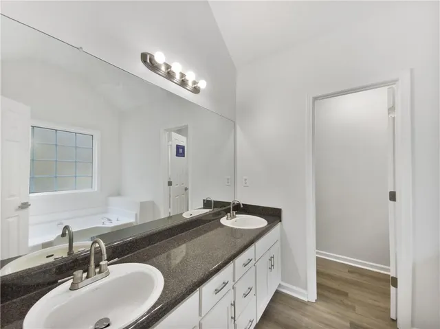 a bathroom with a granite countertop sink and a mirror