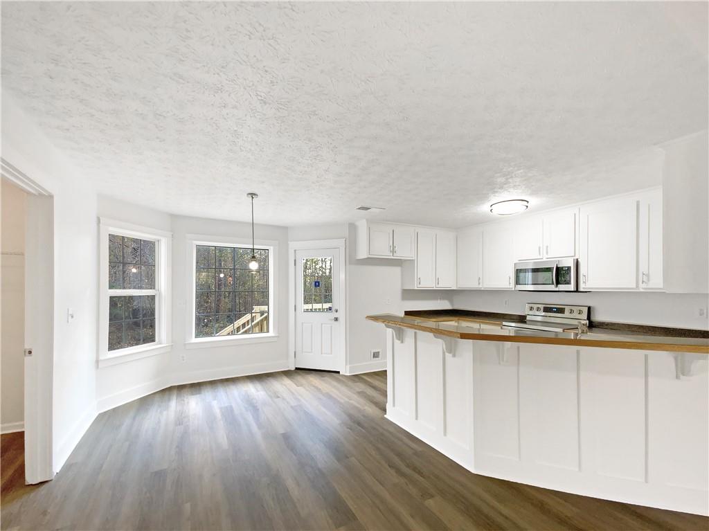 107 Jasons Ridge Griffin, GA 30223 - Photo 9 of 24 a kitchen with stainless steel appliances granite countertop a stove a sink a refrigerator white cabinets and wooden floor