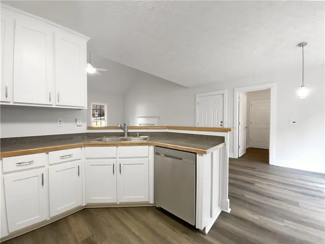 a kitchen with granite countertop white cabinets and a sink