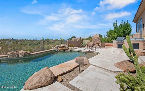 a view of a lake with lawn chairs and a fire pit