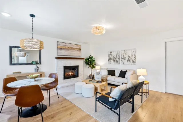 a living room with furniture a chandelier and a fireplace