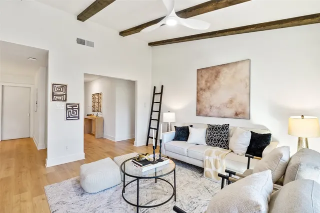 a living room with furniture or couch and a dining table with wooden floor