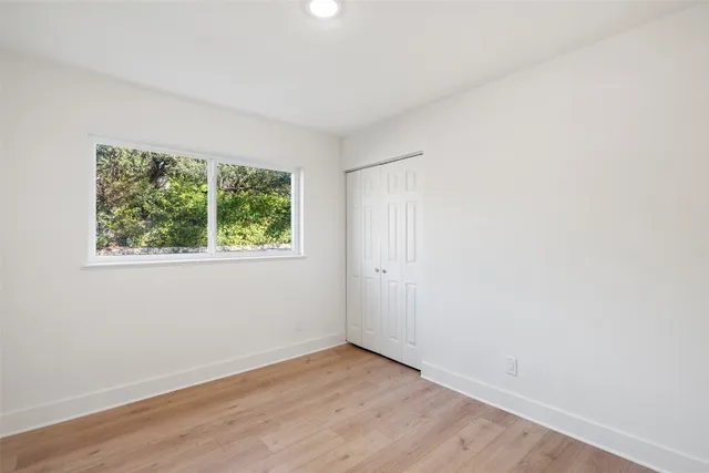 an empty room with windows and closet