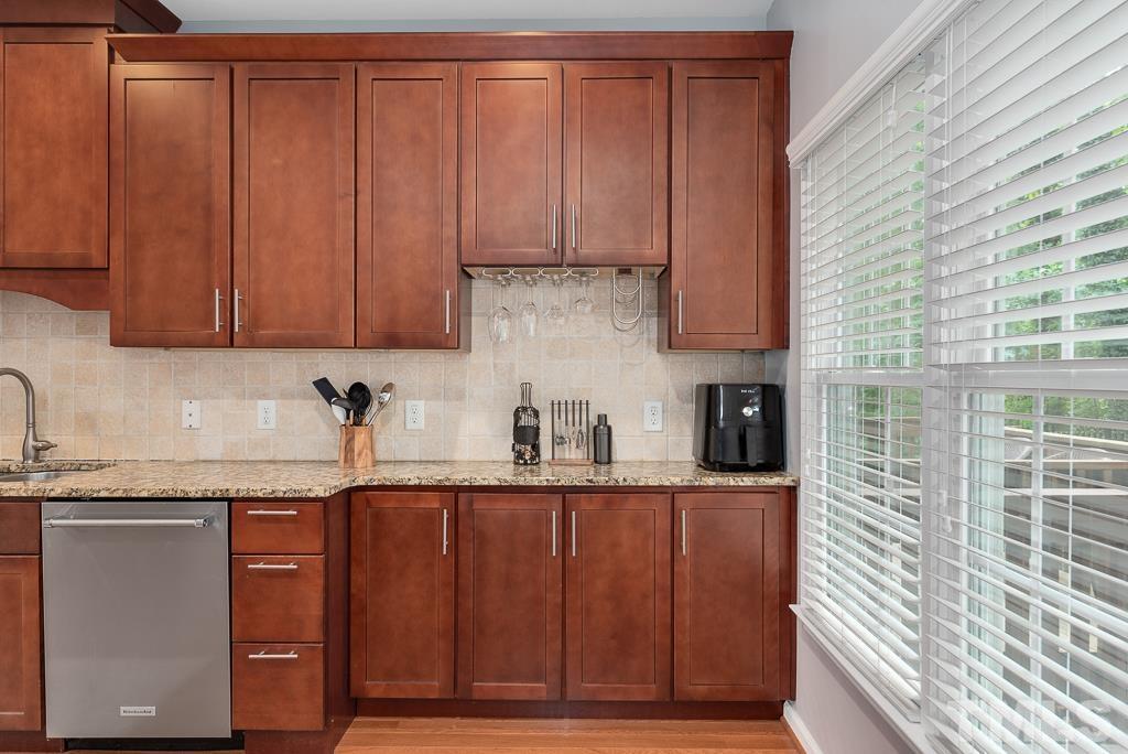 7030 Sandy Forks Road, Unit 103 Raleigh, NC 27615 - Photo 11 of 36 a kitchen with granite countertop a sink cabinets and stainless steel appliances