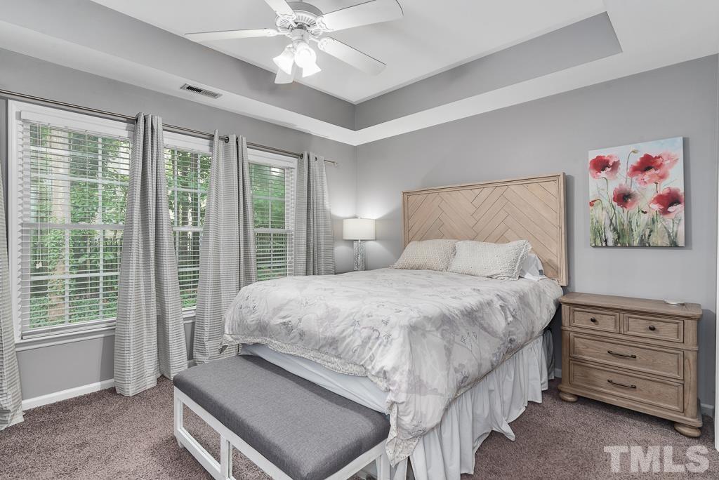 7030 Sandy Forks Road, Unit 103 Raleigh, NC 27615 - Photo 13 of 36 a bedroom with a bed and a chandelier