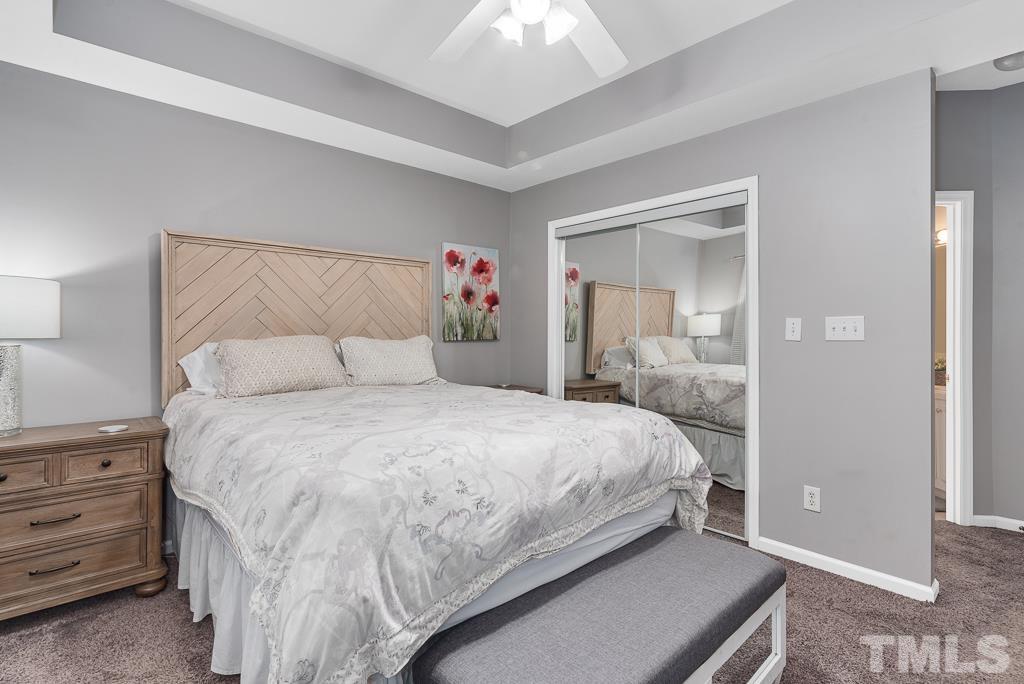 7030 Sandy Forks Road, Unit 103 Raleigh, NC 27615 - Photo 14 of 36 a bedroom with a bed and a chandelier