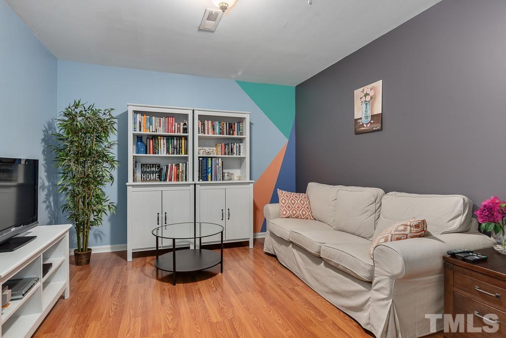 7030 Sandy Forks Road, Unit 103 Raleigh, NC 27615 - Photo 25 of 36 a living room with furniture and a wooden floor