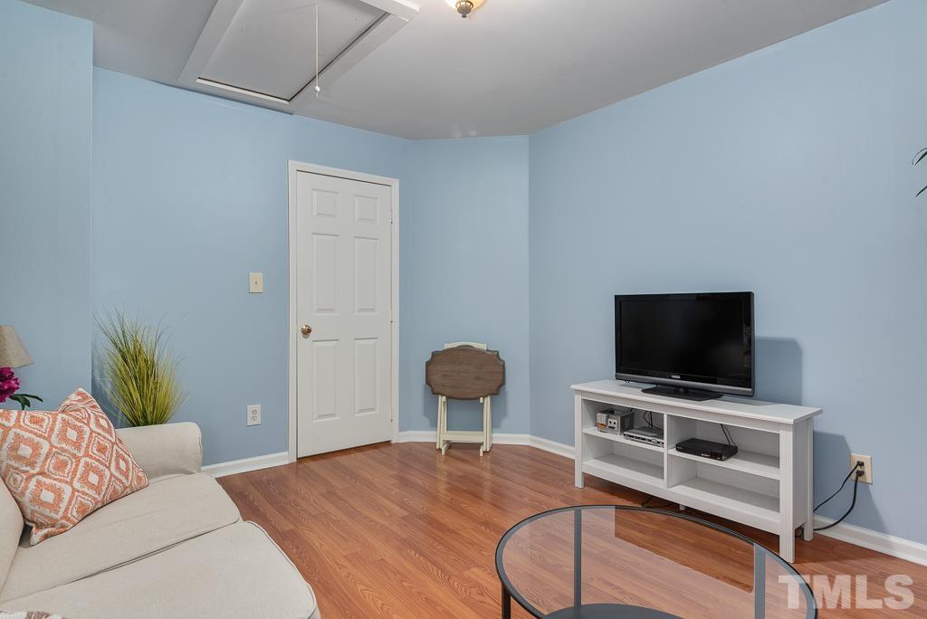 7030 Sandy Forks Road, Unit 103 Raleigh, NC 27615 - Photo 26 of 36 a living room with furniture and a flat screen tv