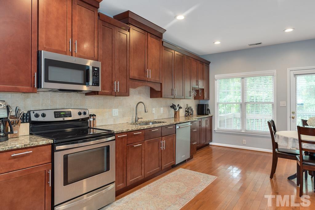 7030 Sandy Forks Road, Unit 103 Raleigh, NC 27615 - Photo 8 of 36 a kitchen with a stove a sink and a microwave