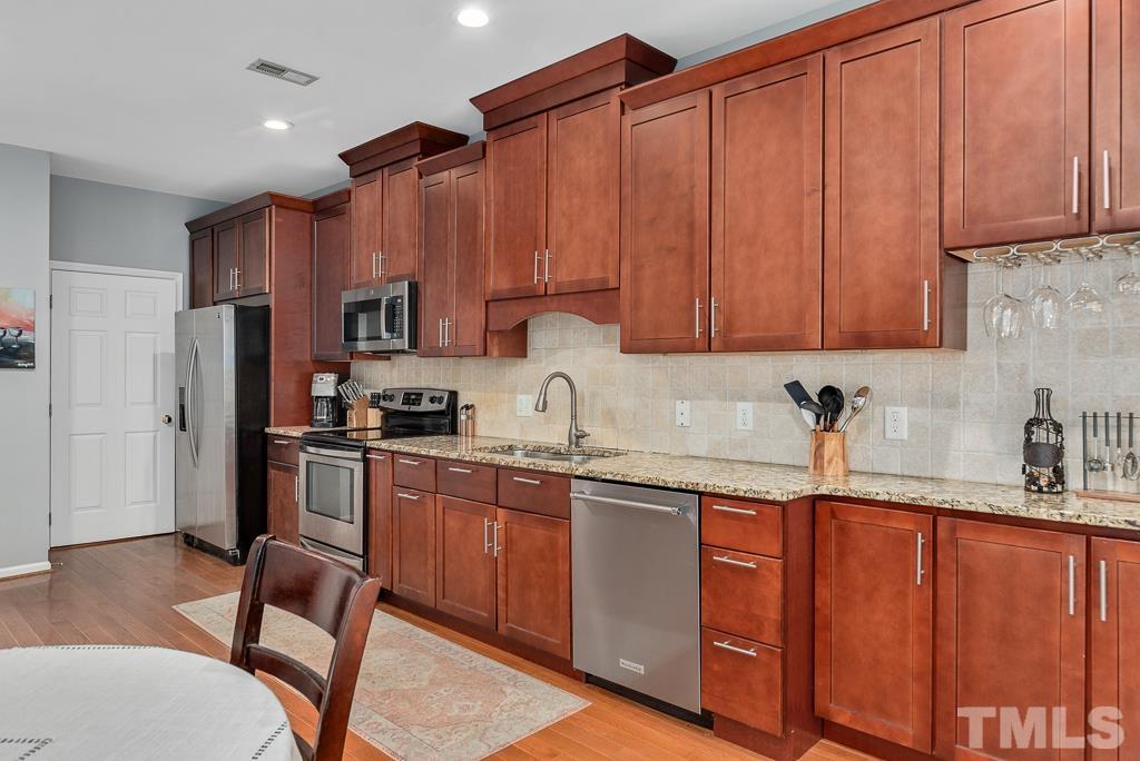 7030 Sandy Forks Road, Unit 103 Raleigh, NC 27615 - Photo 9 of 36 a kitchen with stainless steel appliances granite countertop a refrigerator sink and cabinets