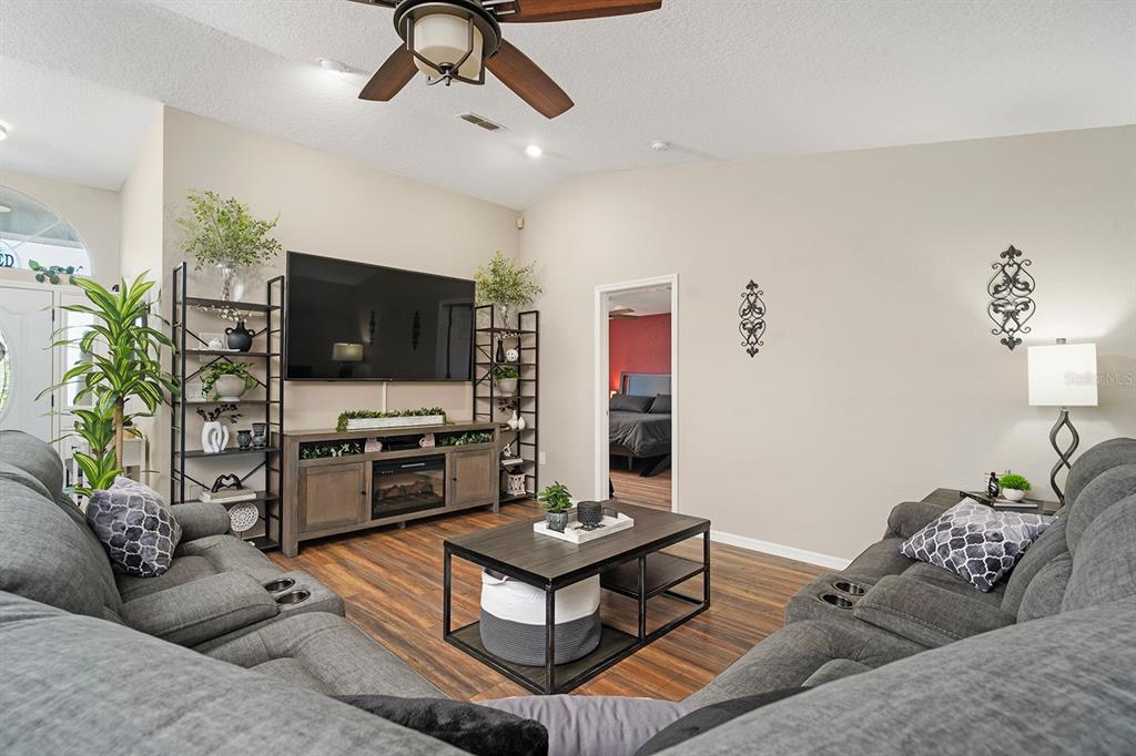10464 Henderson Street Spring Hill, FL 34608 - Photo 12 of 62 a living room with furniture and a flat screen tv