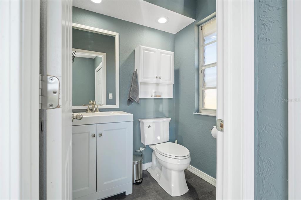 10464 Henderson Street Spring Hill, FL 34608 - Photo 23 of 62 a bathroom with a toilet sink and mirror