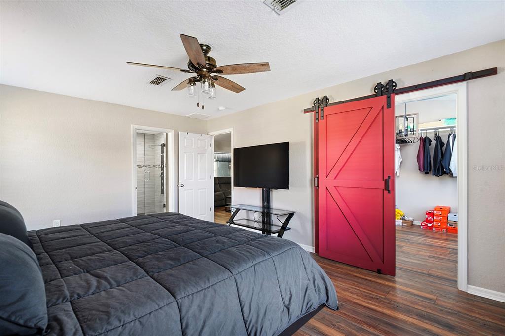 10464 Henderson Street Spring Hill, FL 34608 - Photo 31 of 62 a bedroom with a bed and a flat screen tv