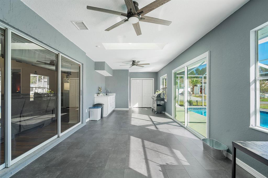 10464 Henderson Street Spring Hill, FL 34608 - Photo 6 of 62 a spacious bedroom with a large bed and a chandelier fan