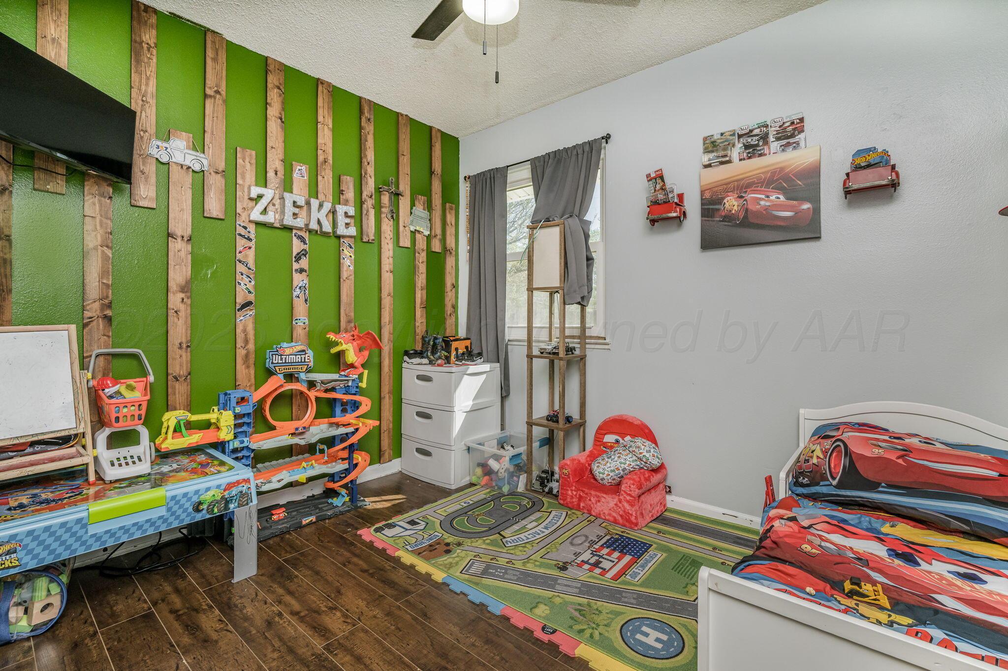 2907 South Manhattan Street Amarillo, TX 79103 - Photo 11 of 16 a bedroom with furniture and a flat screen tv