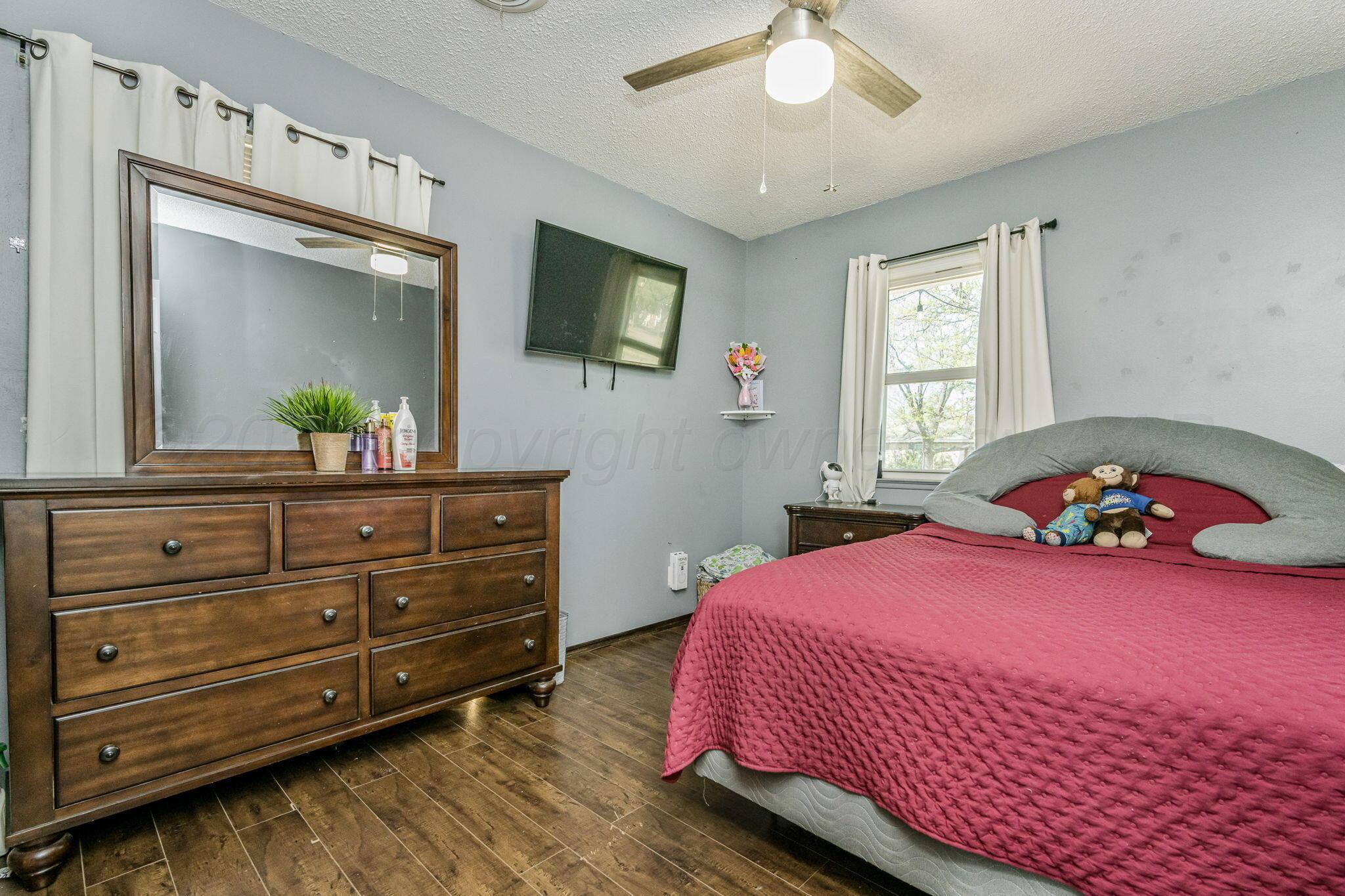 2907 South Manhattan Street Amarillo, TX 79103 - Photo 12 of 16 a bedroom with a bed and a chandelier